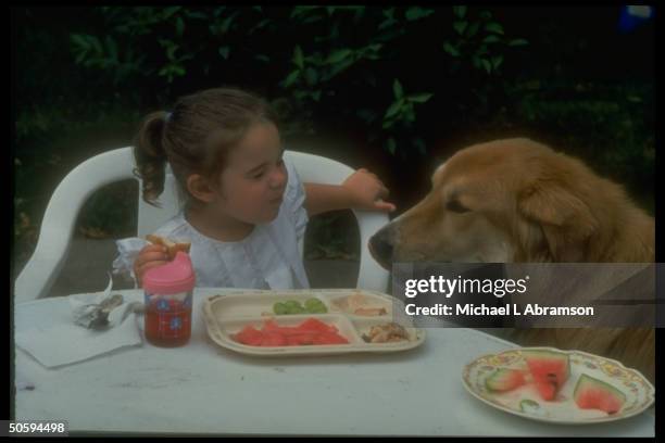 Yr-old Jessica DeBoer sharing lunch w. Dog Miles, re adoptive parents loss of custody battle resulting in her imminent return to biological parents.