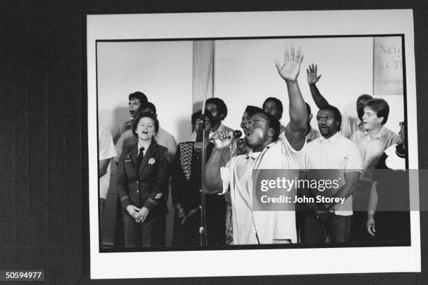 Male prisoner leading members of the San Quentin Mass Choir in song at the prison chapel; the choir is made up of male prisoners & 18 female...
