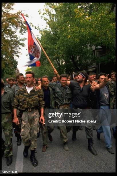 Bosnian Serb troops marching w. Flag, protesting conditions on battle & home fronts, in mutiny by 1000 veteran civil war 1st Krajina Corp. Troops.