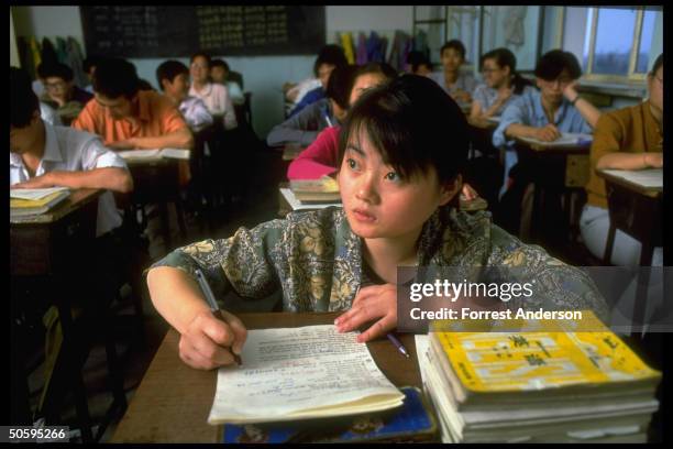 Girl student in front row taking notes in 1st-yr. High school English class at Zhengze private middle-high School.