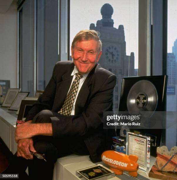 Viacom Inc. Chmn. Sumner Redstone in office w. Paraphernalia fr. Various co. Divisions, incl. Plastic blimp bearing Nickelodeon cable TV station logo.
