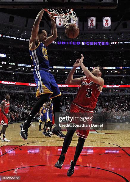 Shaun Livingston of the Golden State Warriors dunks over Doug McDermott of the Chicago Bulls at the United Center on January 20, 2016 in Chicago,...