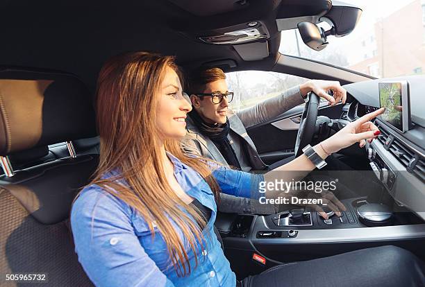 porträt von attraktive junge paar fahren in luxus-auto in der stadt - auto navigation stock-fotos und bilder
