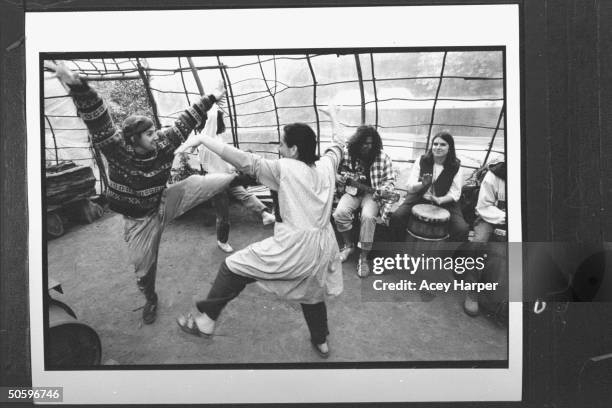 Hofstra Univ. Students Gale Greenstein & Daniel Elison doing a Native Amer-type dance while others play drums & guitar at the Green Tortoise People...