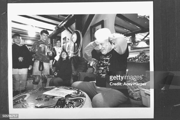 Author & '60s guru Ken Kesey trying on his Polish Navy hat, as four Hofstra Univ. Students look on at Kesey's home; the students are part of prof...