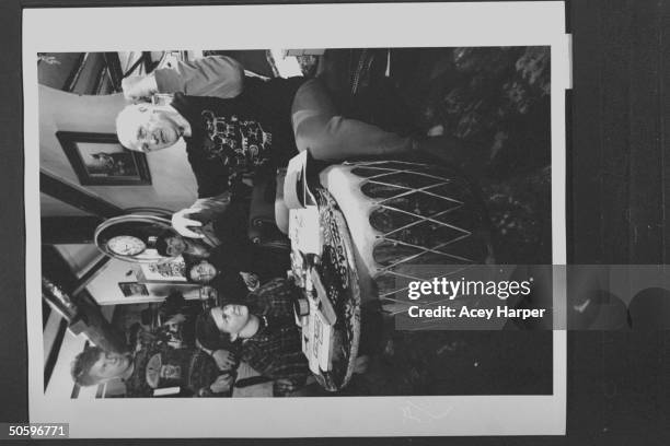 Hofstra Univ. Prof Douglas Brinkley looking on as author & '60s guru Ken Kesey chats w. A small group of students around drum table at his home; the...