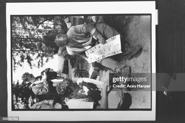 Hofstra Univ. Prof Douglas Brinkley sitting on log as he goes over a map of his intended journey w. A few students fr. His An Amer. Odyssey: Art and...