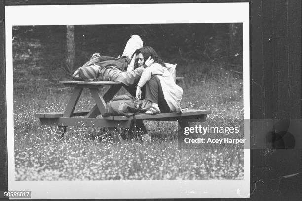 Hofstra Univ. Student Daniel Elison caressing Gale Greenstein's face at picnic table & bench in dandelion covered area; they are members of Douglas...