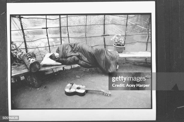 Hofstra Univ. Student Shana Westhoff fast asleep while curled up in sleeping bag on bench nr. Guitar at the Green Tortoise People compound; Shana is...