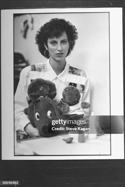 Suburban housewife Andrea , the sad victim of adoption scam perpetator Angela Andrews, holding stuffed toy animals incl. Barney, the purple dinosaur...