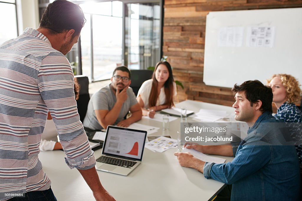 Young man giving business presentation to colleagues