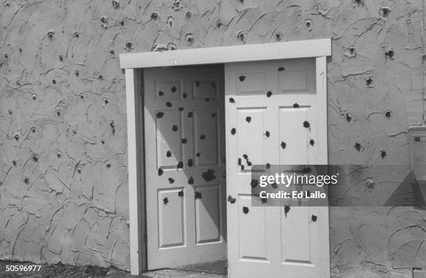 Closeup of movie set replica of Davidian compound doorway & walls riddled w. Bullet holes from ATF agents attack, during break in filming TV movie In...