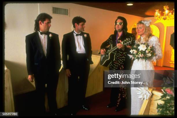 Elvis impersonator Norm Jones serenading newly-weds Vicki Lusk & Wendell Gilbert during marriage ceremony at Graceland Wedding Chapel.