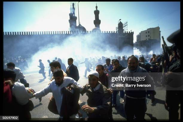 Demonstrators fleeing tear gas fired into crowd by riot police after prayers & protest against massacre of Muslims by Jewish settler in Hebron, nr....
