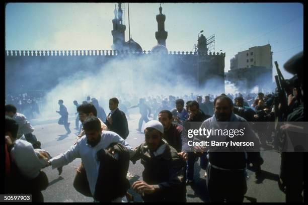 Demonstrators fleeing tear gas fired into crowd by riot police after prayers & protest against massacre of Muslims by Jewish settler in Hebron, nr....