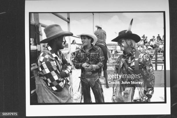 Actor Luke Perry as rodeo star Lane Frost chatting w. Two rodeo clowns in ring during a breaking in the filming of the movie 8 Seconds.