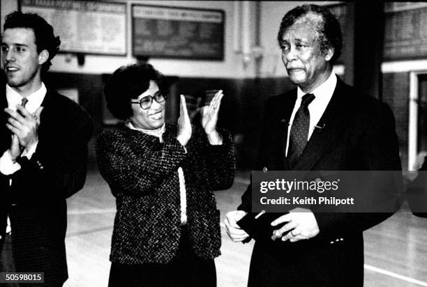 Surgeon Gen. Nominee Dr. Joycelyn Elders standing nr. Unident. Man & clapping for her husband Oliver as he holds award presented to him by school...