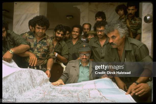 Chmn. Yasser Arafat & mil. Aides pouring over map of Beirut, plotting Palestinian strategy in hideout nr. City during Israeli invasion siege of...