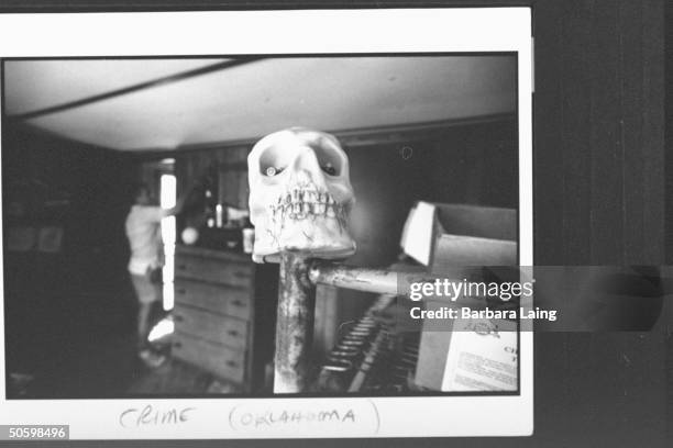 Plastic human skull w. Spent bullet cartridges in each eye decorating the bedpost of bunk bed in bedroom at mobile home of murder victim Lonnie...