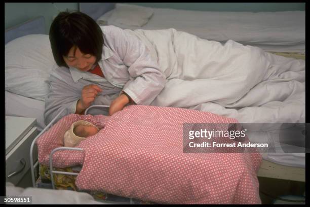 Mother & newborn in bed & crib, at Beijing No. 6 Hospital, re proposed eugenics law aimed at diseased & retarded to improve quality of population.