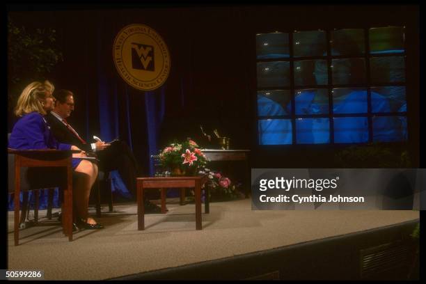 First Lady Hillary Rodham Clinton sitting onstage with Sen. Jay Rockefeller , watching video screen display during health care forum at West Virginia...