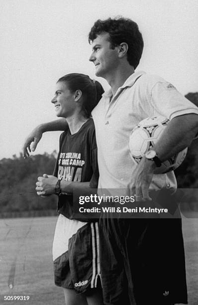 Univ. Of NC soccer coach Anson Dorrance w. His arm around star player, all-American forward Mia Hamm, as he holds ball during practice on the Univ's...