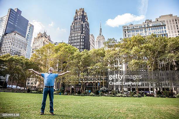 happy senior man strecke die arme in die stadt - bryant park stock-fotos und bilder