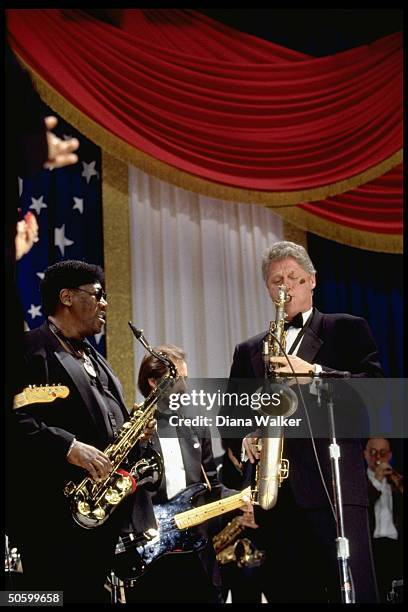 Pres. Bill Clinton playing saxophone, jamming w. Musician Clarence Clemons at DC Armory Ball during inaugural wk. Festivities.