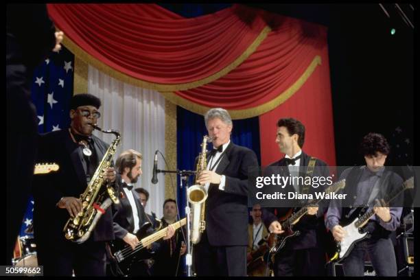 Pres. Bill Clinton playing saxophone, jamming w. Musician Clarence Clemons & band at DC Armory Ball during inaugural wk. Festivities.