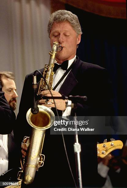 Pres. Bill Clinton playing saxophone at DC Armory Ball during inaugural wk. Festivities.