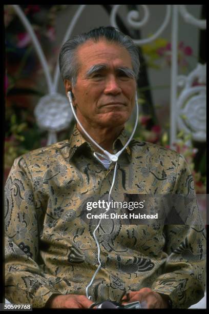 Japanese PM Tomiichi Murayama sporting batik shirt, wearing earphones, during Asia-Pacific Economic Cooperation summit.