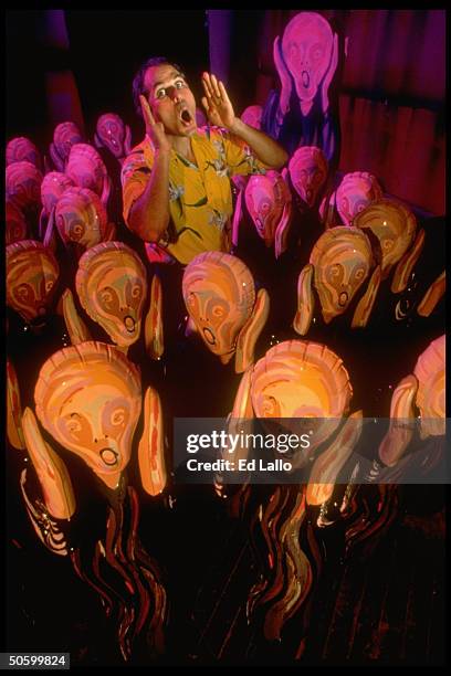 Entrepreneur Robert Fishbone screaming as he stands amid 18 or more Scream dolls, 4 1/2-ft simulacra of Norwegian artist Edvard Munch's The Scream,.