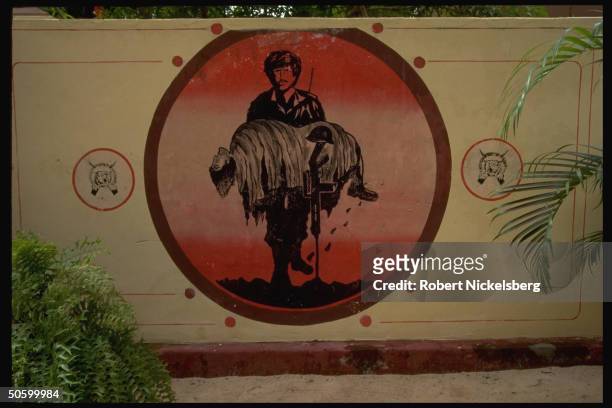 Billbd. Imaging fighter carrying fallen comrade flanked by logo of Tamil separatist Liberation Tigers of Tamil Eelam movement.