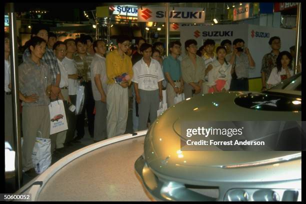 Crowd around Japanese exhibit displaying Mitsubishi HSR IV at auto show featuring for-made top-of-line cars.