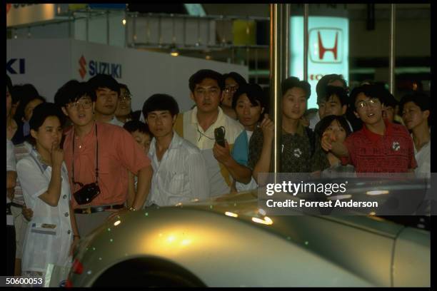 Crowd around Japanese exhibit displaying Mitsubishi HSR IV at auto show featuring for-made top-of-line cars.