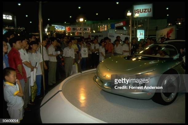 Crowd around Japanese exhibit displaying Mitsubishi HSR IV at auto show featuring for-made top-of-line cars.