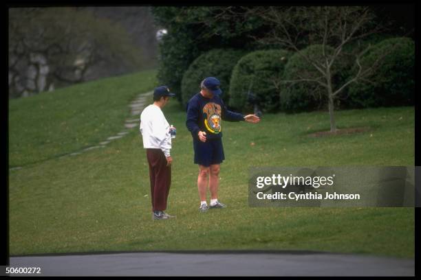 Pres. Bill Clinton & childhood friend David Leopoulis on WH lawn after jogging on mall, watching 1st cat Socks running.