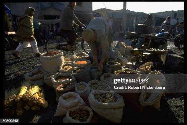 Main street market spice stand arraying exotic mix in sacks.