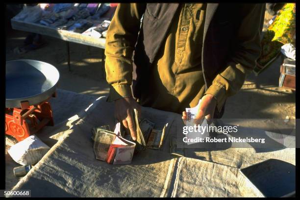 Main street market stand seller counting money.