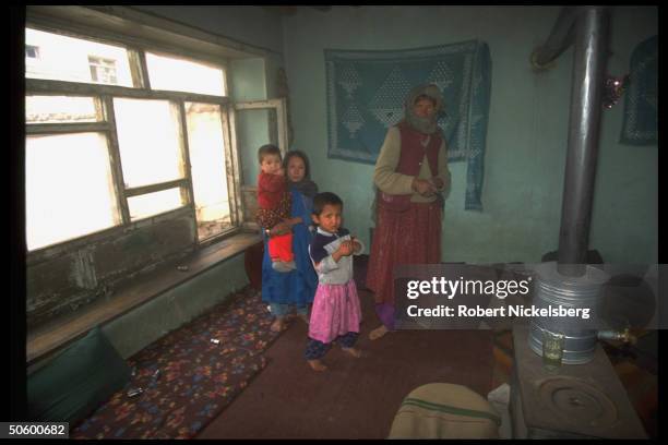 Woman & children in potbelly stove-equipped home in civil war lull after Taliban faction rout of city-sieging Hekmatyar mujahedin, prob. In govt-held...