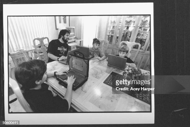 Apple Computer cofounder Steve Wozniak w. His Apple Macintosh Powerbook computer sitting at dining table, tutoring his kids Jesse Sarah & Gary while...