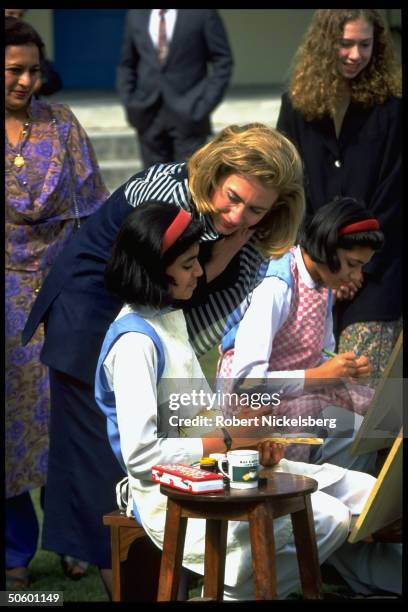 First Lady Hillary Rodham Clinton watching students paint in art class, at college for girls with daughter Chelsea , on Asian tour stop in Islamabad,...