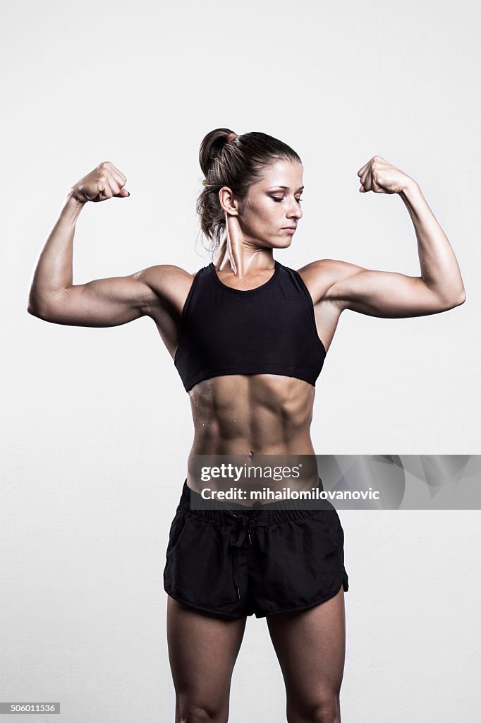 Fitness woman flexing muscles