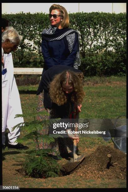 1st Lady Hillary Rodham Clinton watching daughter Chelsea plant sapling during visit to college for girls, on Asian tour stop in Islamabad, Pakistan.