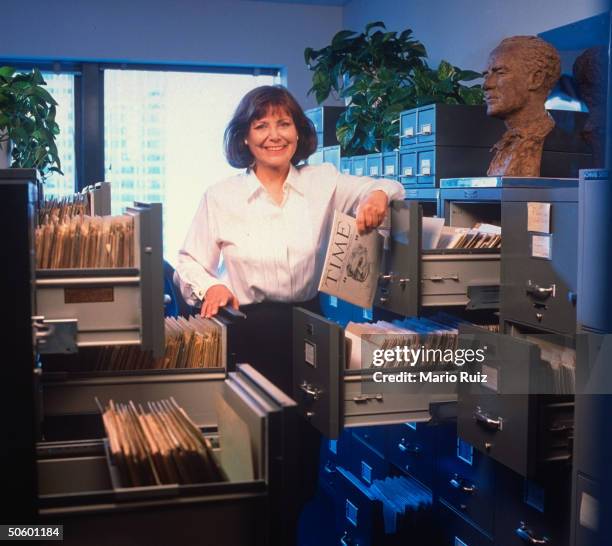 Archivist Elaine Felsher, retiring after 27 yrs., amid her office files, w. 1922 TIME 1st pre-issue & Jo Davidson bust of Henry Luce.