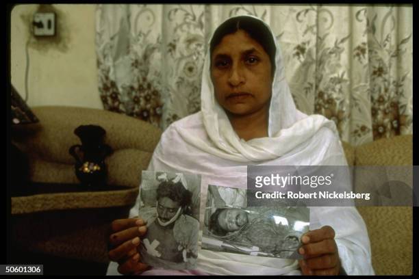 Mother w. Pics of her sons as victims of drive-by shooting, 1 killed, 1 losing leg in 1 of daily incidents of sectarian violence in lawless Karachi,...