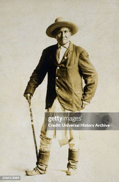 Geronimo, full-length portrait, standing, facing front, with walking stick. Photo by: