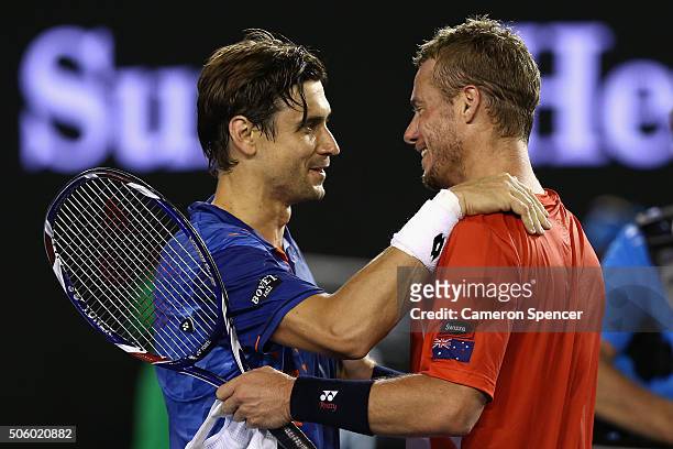 David Ferrer of Spain and Lleyton Hewitt of Australia meet at the net following their second round match and Hewitt's final match during day four of...