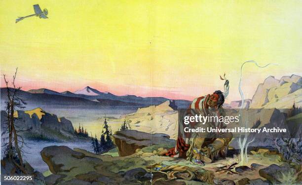 The great spirit by Udo Keppler, 1872-1956, artist 1914. Illustration shows a Native man sitting before a small fire in a wilderness setting, holding...