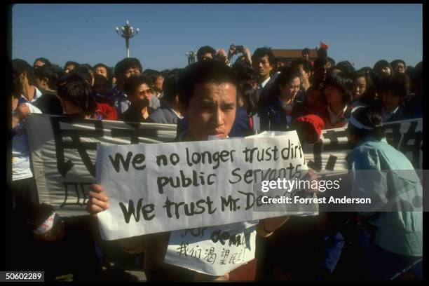 Youth w. We no longer trust dirty public servants We trust Mr. Democracy sign during student-led, pro-democracy protests in Tiananmen Sq.